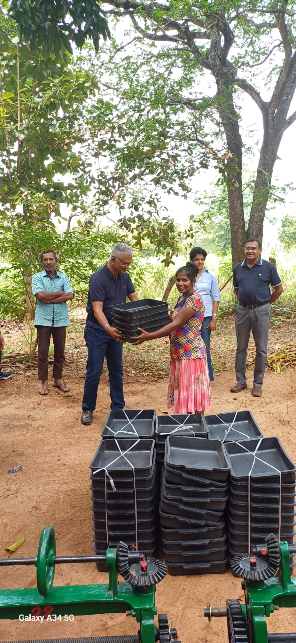 S.K. Chem Solutions team handing latex trays to rubber smallholders